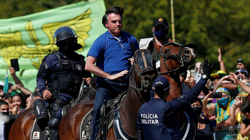 FILE PHOTO: Brazil's President Jair Bolsonaro rides a horse during a meeting with supporters protesting in his favor, amid the coronavirus disease (COVID-19) outbreak, in Brasilia