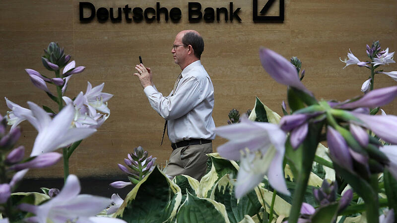 FILE PHOTO: A man walks past a Deutsche Bank office in London