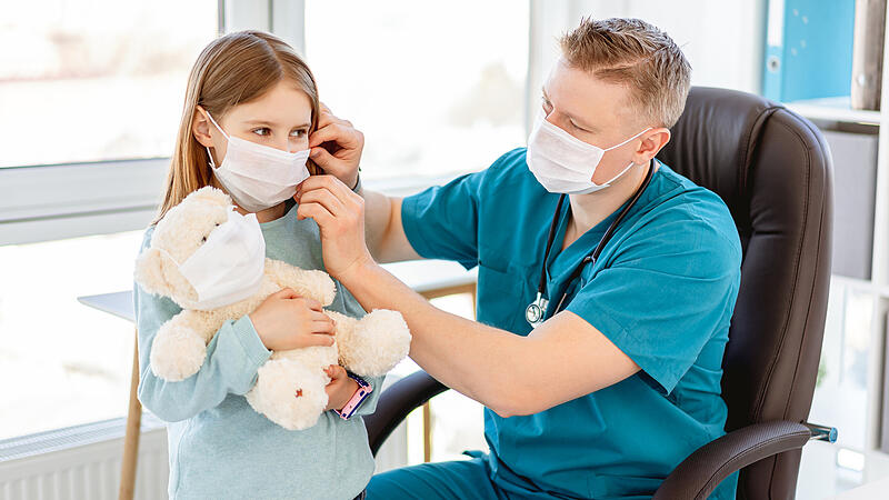 Doctor putting mask on girl