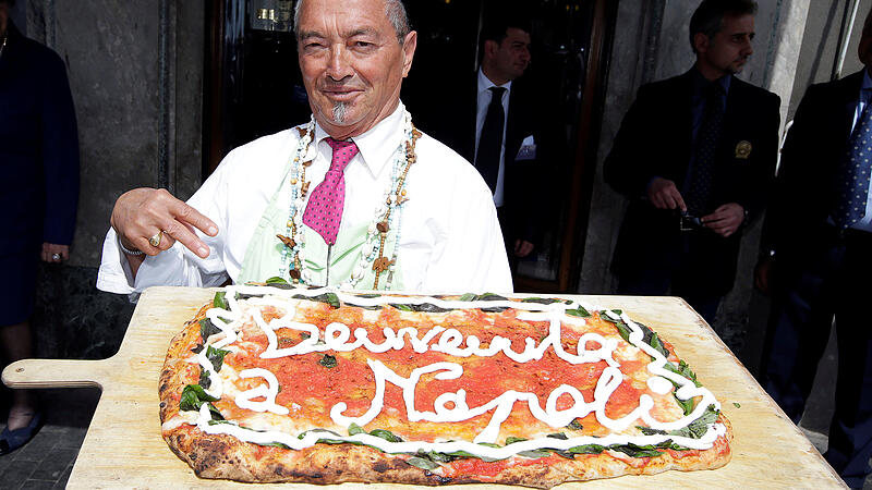 Neapolitan pizza maker Alfredo nickname "Il Cavaliere" shows a pizza with the words " Welcome to Naples"  dedicated to Camilla Duchess of Cornwall as she arrives to visit Naples