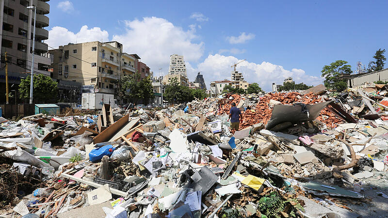 A man walks on the rubble of damaged buildings in the aftermath of a massive explosion in Beirut