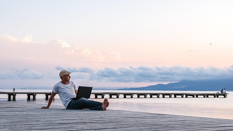 Man working with laptop on pier