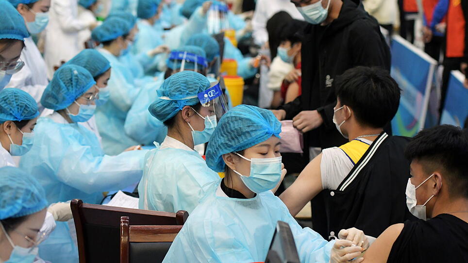 Medical workers inoculate students with the vaccine against the coronavirus disease in Qingdao