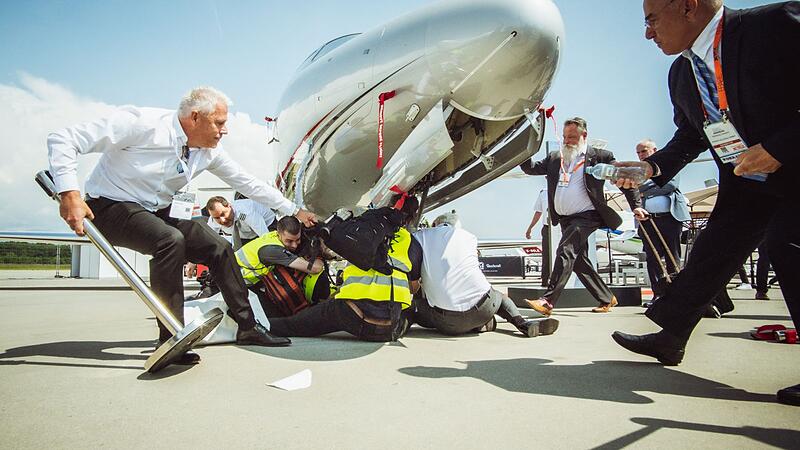 Climate activists chain themselves to airplanes