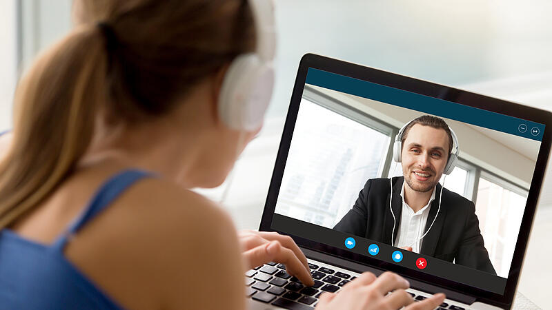 Man and woman in headphones communicating online by video call