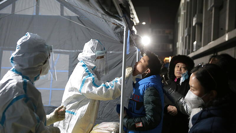 Medical worker in protective suit collects a swab from a resident for nucleic acid testing, following new cases of coronavirus disease (COVID-19) in Beijing