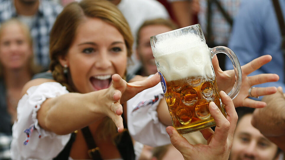 A visitor reaches for of the one of the first mugs of beer during opening ceremony for 180th Oktoberfest in Munich