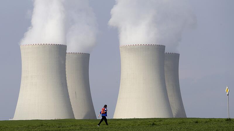 A man walks past cooling towers of the Temelin nuclear power plant near Tyn nad Vltavou