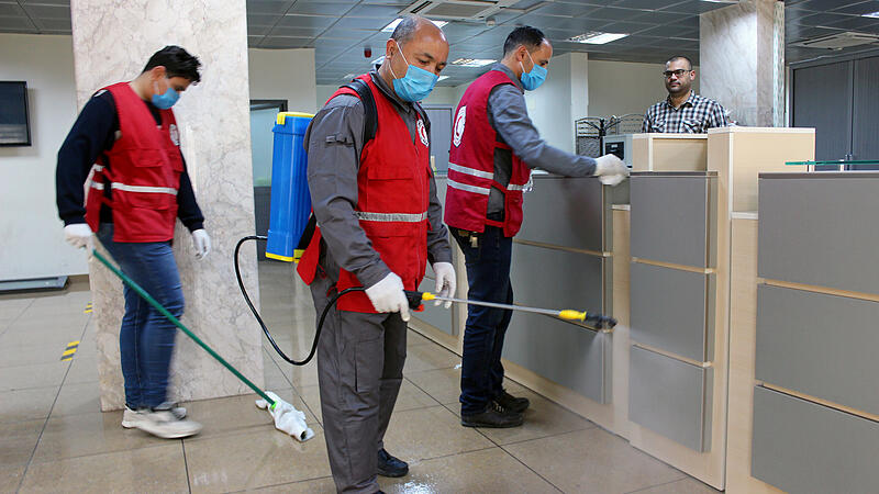 FILE PHOTO: Members of Red Crescent spray disinfectants at government offices in Misrata