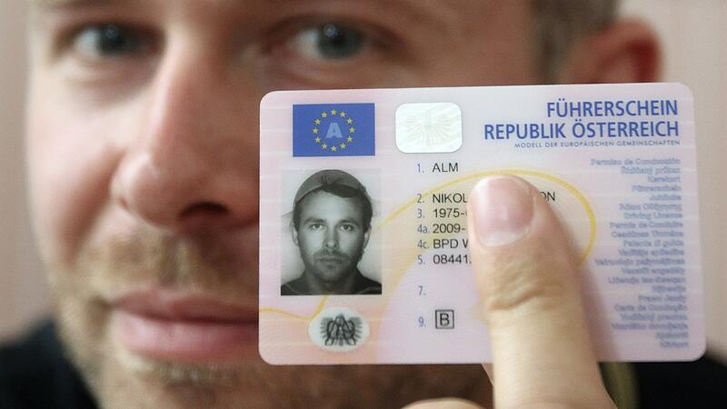Austrian businessman Alm poses with his Austrian driver's licence, depicting him wearing a pasta strainer, during a news conference in Vienna
