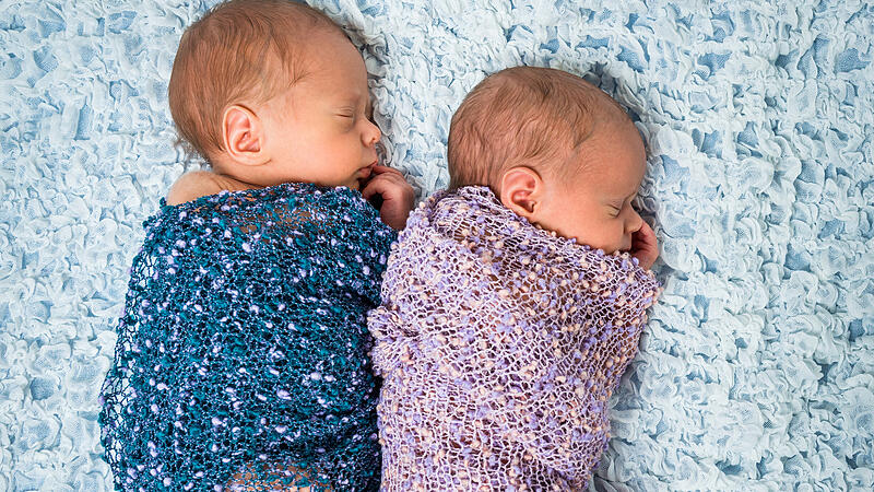 newborn twins l sleeping on a blanket
