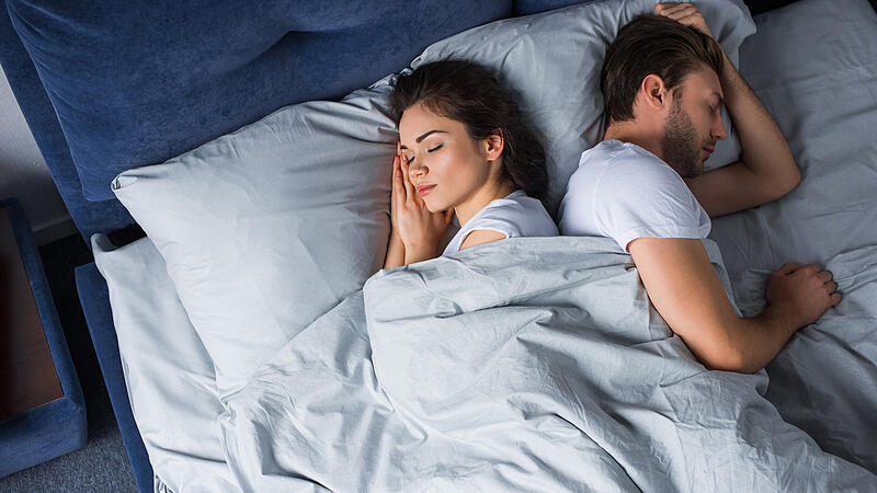 Young couple sleeping in bed in modern bedroom