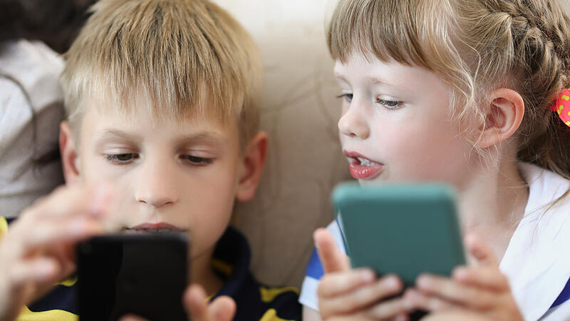 Boy and girl at home looking smartphones close-up