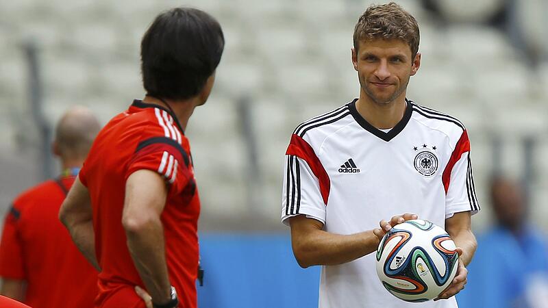 Coach Joachim Loew of the German national team chats with forward Thomas Mueller during practice at Castelo Stadium in Fortaleza