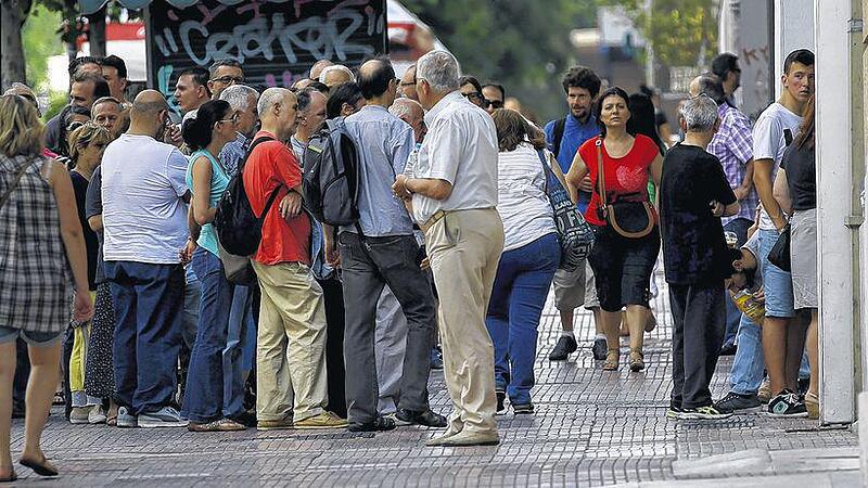 People line up at an ATM in Athens