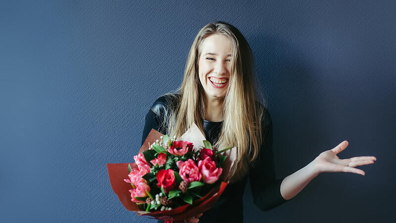 Cute girl with bouquet of red tulips.