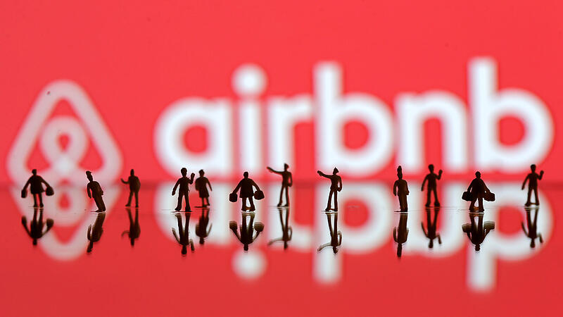FILE PHOTO: A 3D printed people's models are seen in front of a displayed Airbnb logo in this illustration