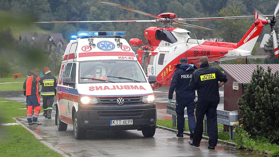 TOPR (Tatra Volunteer Search and Rescue) helicopter and an ambulance are seen as rescuers conduct a rescue operation after a thunderstorm in the Tatra Mountains, in Zakopane