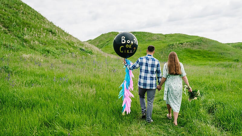 Baby shower party in a field or meadow. Man and woman holding a