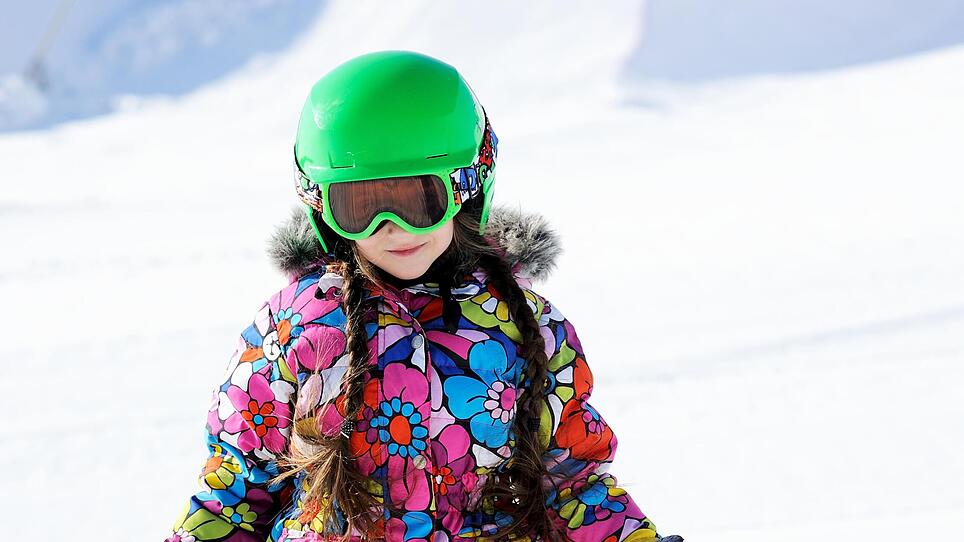 Portrait of little girl skier in sports suit,kind skifahren helm