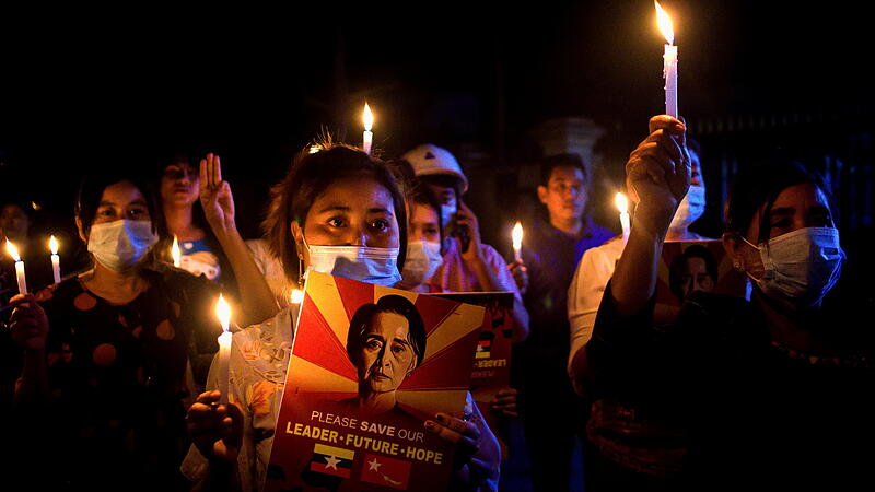 People hold candles during a nationwide night protest against military coup