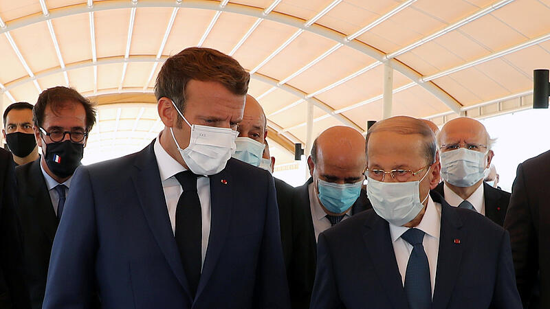 Lebanon's President Michel Aoun welcomes French President Emmanuel Macron upon his arrival at the airport in Beirut
