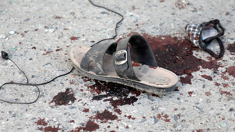 A sandal and bloodstain are seen near a bus which carried employees of an Afghan television station and was bombed, in Kabul