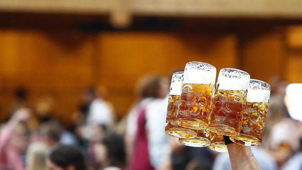 Waiter carries mugs of beer during the opening day of the 184th Oktoberfest in Munich