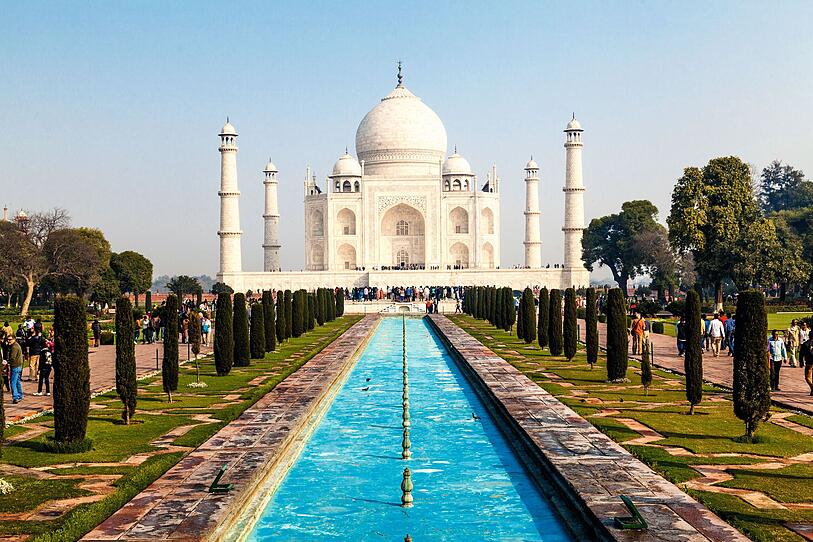 <b>Taj Mahal, Agra (Indien)</b>:  Das spektakuläre Mausoleum aus weißem Marmor am Ufer des Yamuna-Flusses ist eines der berühmtesten Denkmäler Indiens. Der Mogulkaiser Shah Jahan ließ es 1632 zu Ehren seiner Lieblingsfrau Mumtaz Mahal errichten, die bei der Geburt ihres 14. Kindes starb.