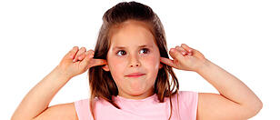 Kind hält sich Ohren zu