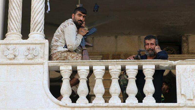 Free Syrian Army fighters, part of the Suqour al-Jabal (Mountain Hawks) brigade, rest with their weapons at their headquarters building in Aleppo