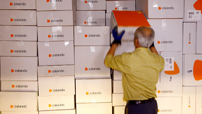 FILE PHOTO: An employee unloads parcel of online mail order company Zalando from a container at the parcel distribution center of Swiss Post in Frauenfeld